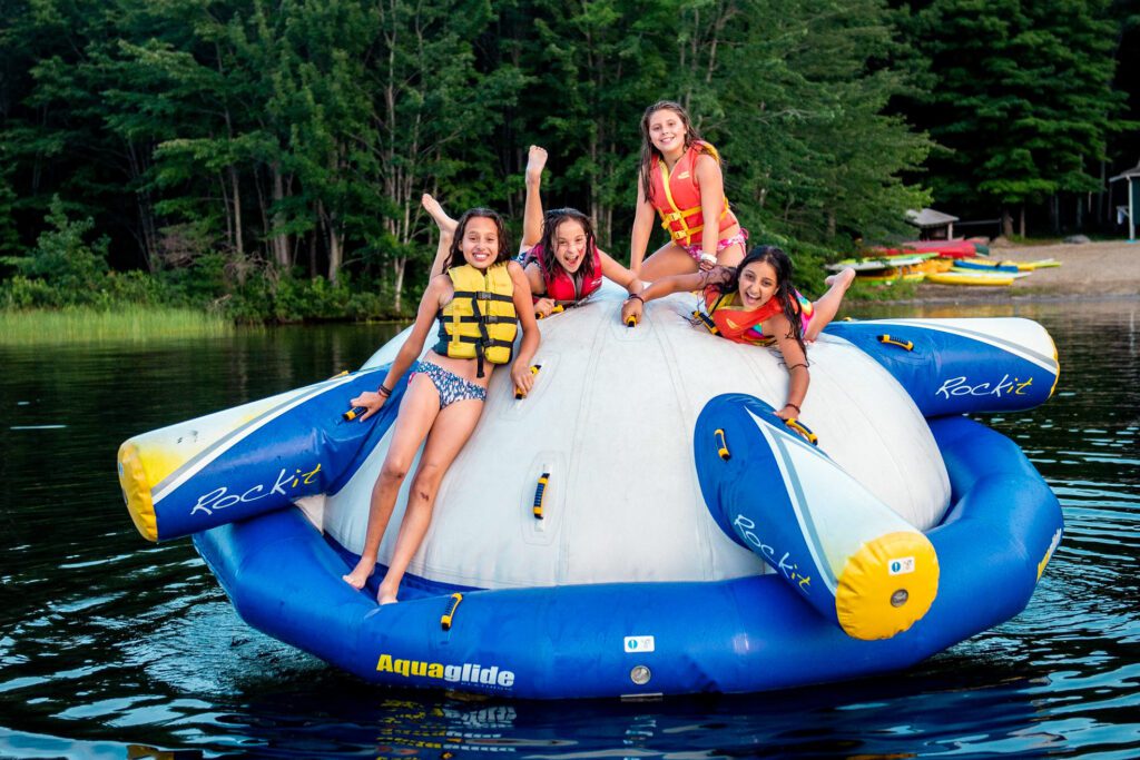 Girls playing on an inflatable water raft